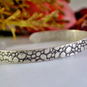 May include: A rustic wooden sign with the text "Welcome to our home" in white lettering. The sign features a distressed finish and a simple, inviting design, perfect for a front porch or entryway.