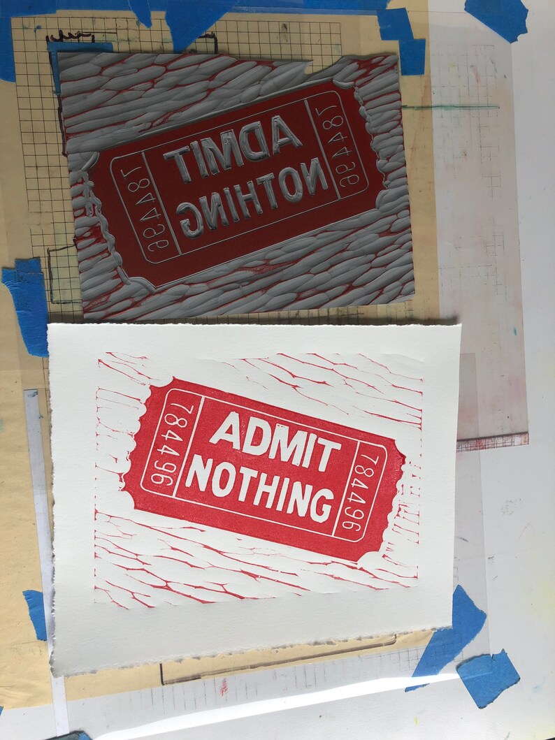 May include: A red and white ticket with the text "ADMIT NOTHING" and the number "784496" printed on it. The ticket is printed on a textured surface.