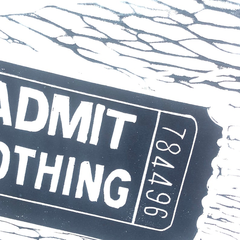 May include: A black and white ticket with the text "ADMIT ONE THING" and the number "964781" printed on it.