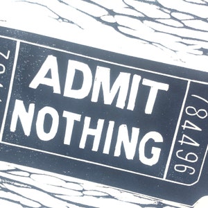 May include: A black and white ticket with the text "ADMIT NOTHING" and the number "964748" printed on it.