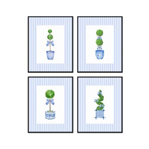 May include: Set of four framed prints featuring watercolor illustrations of topiary trees in blue and white planters with blue ribbons. The prints have a blue and white striped background.