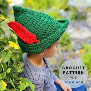 Può includere: Un cappello verde all'uncinetto con un dettaglio a forma di piuma rossa. Il cappello ha una parte superiore a punta e un piccolo bordo. L'immagine include il testo "CROCHET PATTERN PDF Download".