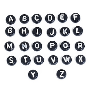 May include: Black alphabet letter beads with white lettering. The beads are arranged in alphabetical order from A to Z.