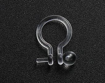 May include: A pair of clear plastic earring backs with a small pearl-like bead on each back.
