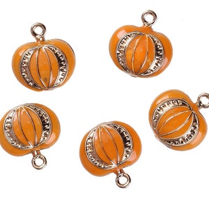 May include: Five gold-colored pumpkin charms with orange enamel. Each charm has a loop for attaching to a necklace, bracelet, or other jewelry.