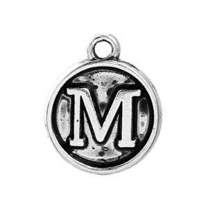 May include: A silver-toned metal charm with the letter "M" in a bold, sans-serif font, centered within a circular frame. The charm has a loop at the top for attachment and a slightly antiqued finish, suggesting a vintage or handcrafted aesthetic.