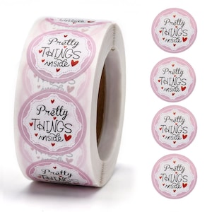 May include: Roll of pink and white round stickers with the text "Pretty Things Inside" and a red heart.
