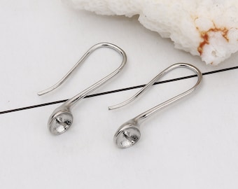 May include: Two silver earring hooks with a round, flat base. The hooks are designed to hold a cabochon or other embellishment.
