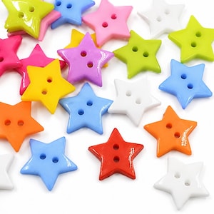 May include: A collection of star-shaped buttons in various colors including red, orange, yellow, lime green, light blue, pink, purple, and white. Each button features a smooth, glossy finish and two centered holes for sewing, arranged in a scattered pattern.
