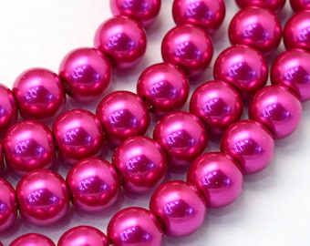 May include: A strand of bright pink round beads. The beads are smooth and shiny, with a pearlescent finish.