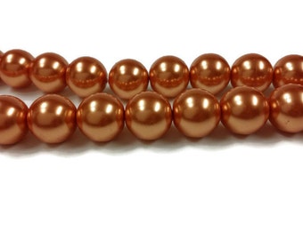 May include: A strand of round, orange-brown pearl beads. The beads have a smooth, glossy finish.