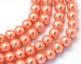 May include: A strand of coral-colored pearl beads. The beads are round and have a smooth, glossy finish.