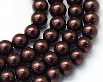 May include: Close-up of multiple strands of dark brown, glossy beads. The beads are round and evenly sized, reflecting light. The beads are arranged in rows, suggesting they are strung together for jewelry making.