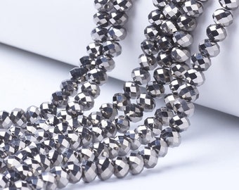 May include: A strand of silver-toned faceted beads. The beads are small and round, and they are strung together on a clear thread.