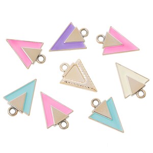 May include: Assortment of eight triangle-shaped metal charms with a gold-tone finish. Each charm features a double-layered design with a smaller triangle inside a larger triangle. The charms are available in a variety of colors, including pink, purple, blue, and cream.