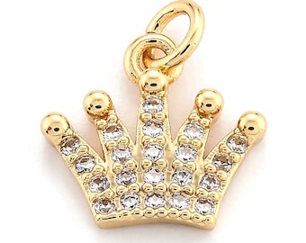 May include: A gold-colored crown charm with clear, sparkling crystals. The charm has a loop at the top for easy attachment to a necklace or bracelet. This jewelry piece is perfect for adding a touch of elegance to any accessory.
