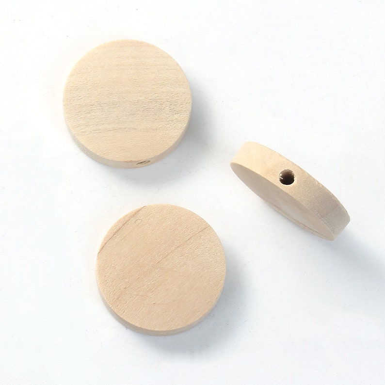May include: Three round wooden beads, two with smooth surfaces and one with a hole drilled through the center.