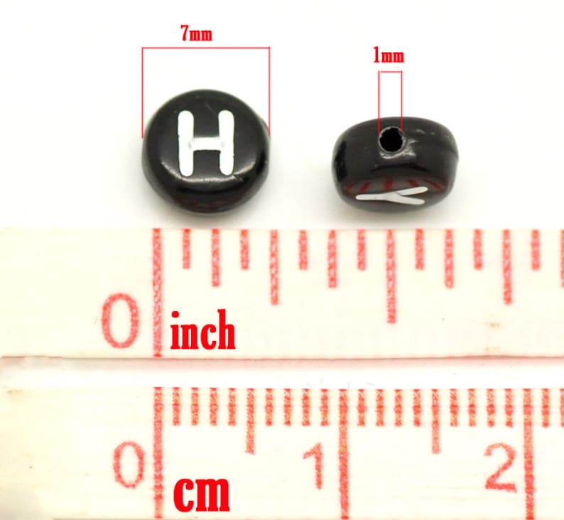 May include: Black plastic letter beads with a white letter "H" on one side and a white letter "Y" on the other side. The beads are 7 mm in diameter and have a 1 mm hole.