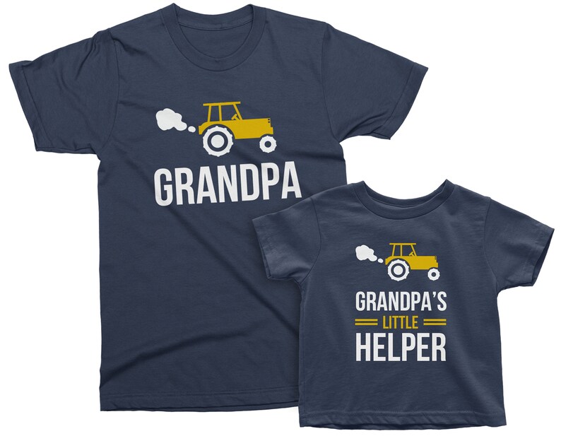May include: Two navy blue t-shirts with a yellow tractor graphic and the text "Grandpa" and "Grandpa's Little Helper".