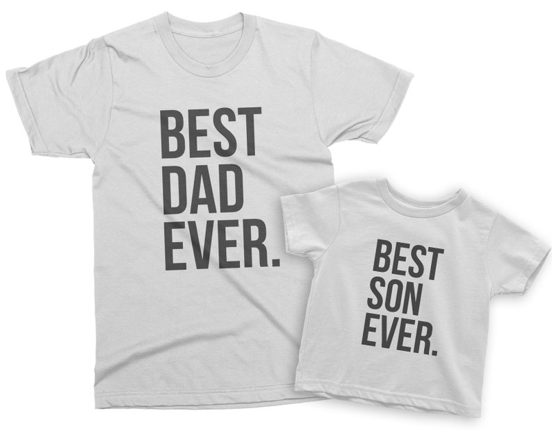 May include: Two white t-shirts with black text. The larger shirt says "BEST DAD EVER." The smaller shirt says "BEST SON EVER."
