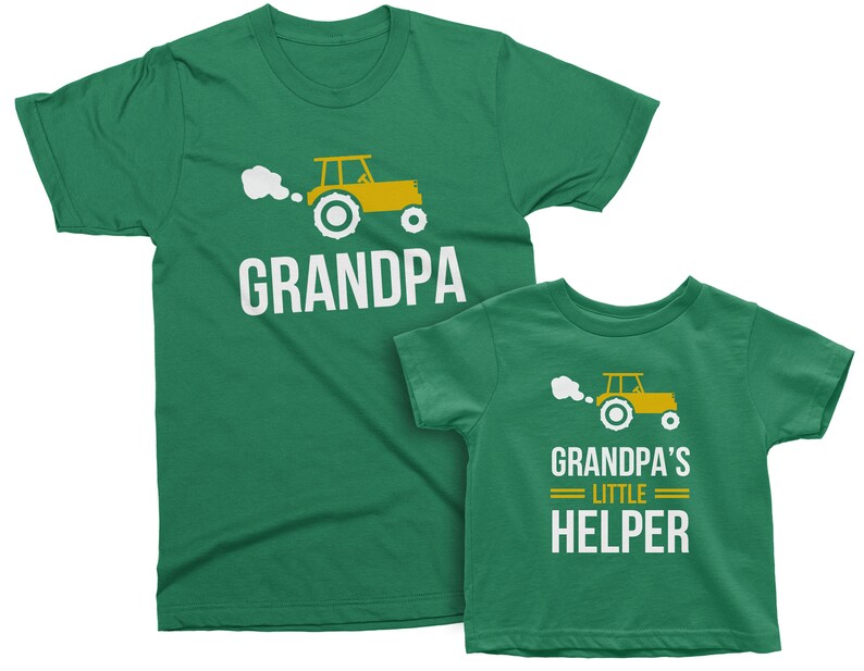 May include: Two green t-shirts with a cartoon tractor design. The larger shirt says "Grandpa" and the smaller shirt says "Grandpa's Little Helper".