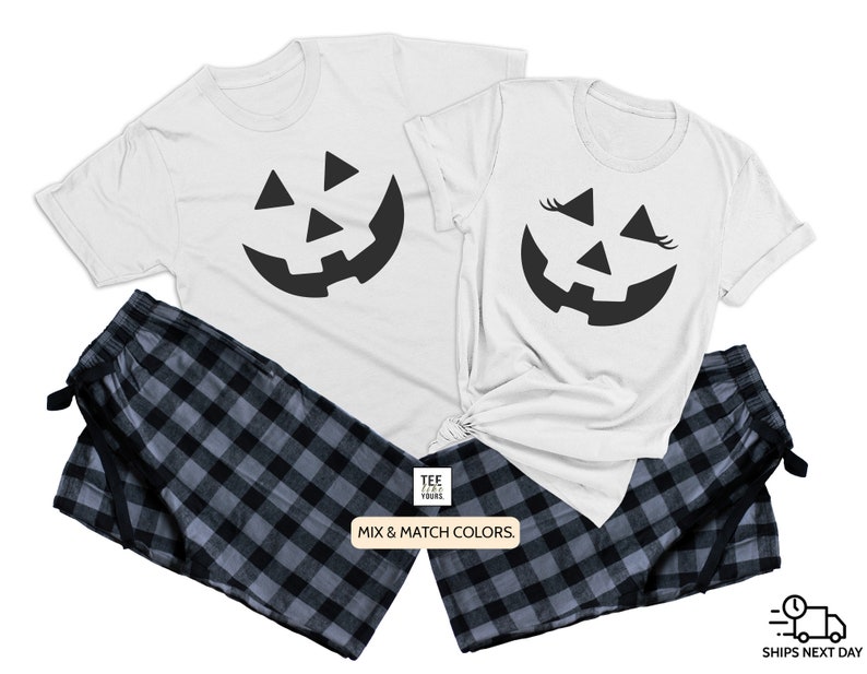 May include: A white t-shirt with a black jack-o'-lantern face graphic. The other t-shirt has a black jack-o'-lantern face with eyelashes. Both shirts are paired with black and gray plaid pajama pants. "Mix & Match Colors." is printed on the bottom of the image.