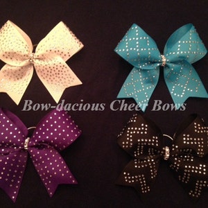 Op de afbeelding: Vier cheer bows met strass in wit, turquoise, paars en zwart.