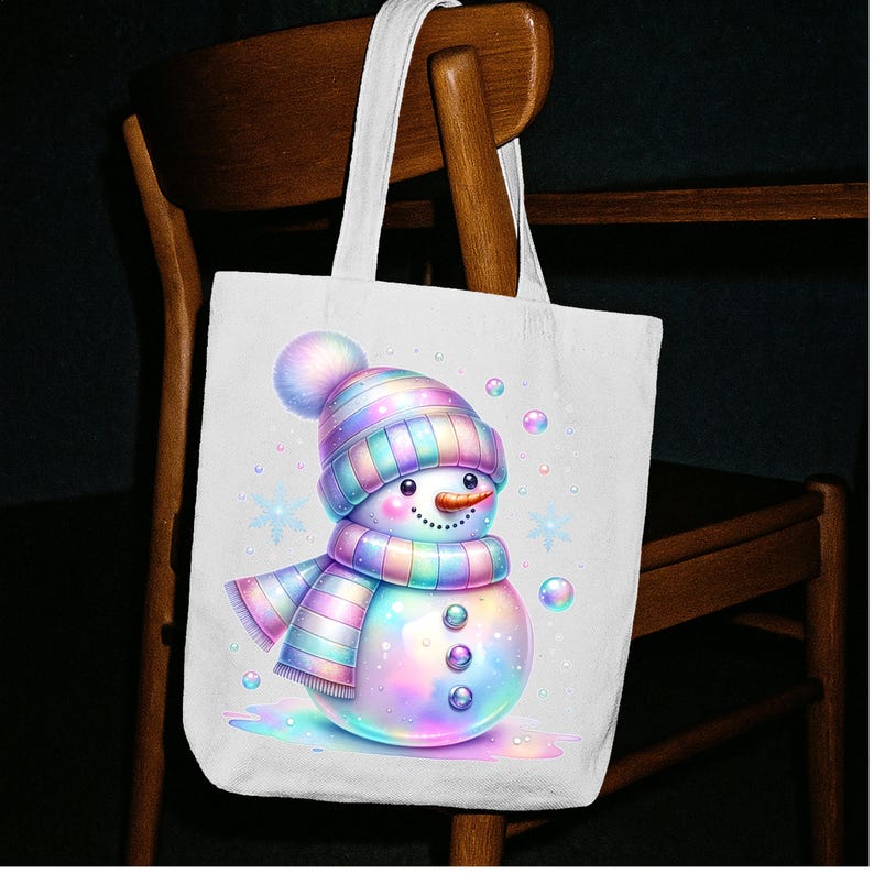 Puede incluir: Bolso tote blanco con una ilustraci&oacute;n de un mu&ntilde;eco de nieve colorido. El mu&ntilde;eco de nieve lleva un gorro y una bufanda a rayas en tonos pastel, una nariz de zanahoria y ojos de bot&oacute;n. Burbujas y copos de nieve completan la escena invernal.