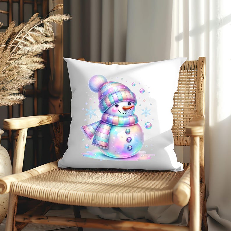 Puede incluir: Un coj&iacute;n cuadrado blanco con un dise&ntilde;o de mu&ntilde;eco de nieve caprichoso. El mu&ntilde;eco de nieve tiene un sombrero, bufanda y botones coloridos, con copos de nieve y burbujas a su alrededor. El coj&iacute;n est&aacute; colocado en una silla tejida.