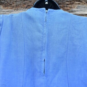 May include: A light blue linen dress with a zipper closure in the back.