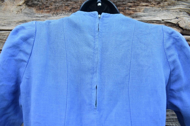 May include: A light blue linen dress with a zipper closure in the back.