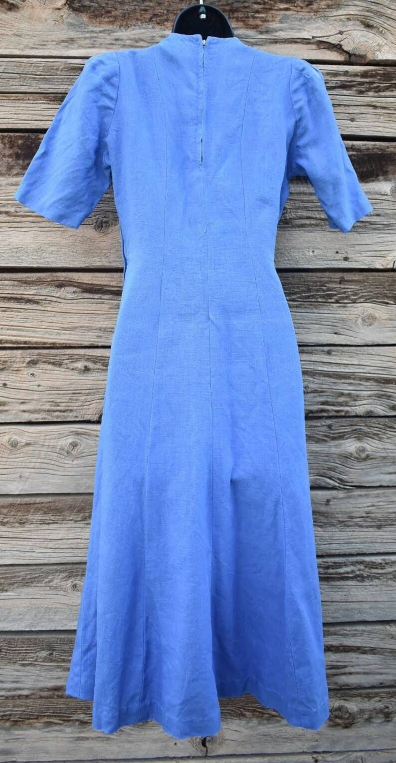 May include: A light blue linen dress with a back zipper and a slightly flared skirt.