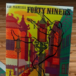 Può includere: Un biglietto vintage per una partita di football americano tra i San Francisco Forty Niners e i Buffalo Bills. Il biglietto è datato 18 ottobre 1949 e presenta un'illustrazione stilizzata di un giocatore di football americano che calcia un pallone. Il biglietto è stampato su uno sfondo giallo con accenti rossi, verdi e blu.