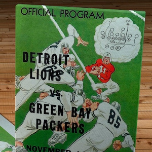 May include: A vintage green and white football program for the Detroit Lions vs. Green Bay Packers game on November 4, 1951 at City Stadium. The program features a drawing of two football players in action and a diagram of a football play. The price is 25 cents.