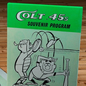 May include: A green and white vintage souvenir program for the Los Angeles Dodgers baseball team. The program features a cartoon illustration of two baseball players. The text "Colt .45s Souvenir Program" and "Los Angeles Dodgers" is printed on the front of the program. The price of the program is 25 cents.