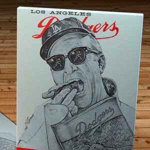 May include: A vintage Los Angeles Dodgers scorecard from 1961. The card features a black and white illustration of a man wearing a baseball cap and sunglasses, holding a cigar. The text "Los Angeles Dodgers" is printed in red on the card.