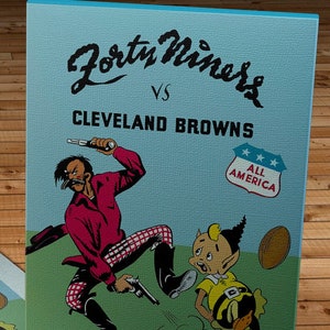 Può includere: Una copertina di programma di partita di football americano vintage del 1947 con un'illustrazione di cartone animato di un giocatore dei 49ers che calcia un giocatore dei Browns di Cleveland. La copertina del programma è blu con un campo verde e il testo "Forty Niners vs CLEVELAND BROWNS" e "OCTOBER 26, 1947".