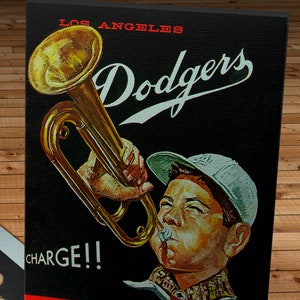 May include: A vintage Los Angeles Dodgers baseball scorecard from 1962. The card features a cartoon illustration of a boy playing a trumpet with the words "CHARGE!!" and "Los Angeles Dodgers Stadium" printed on the card.
