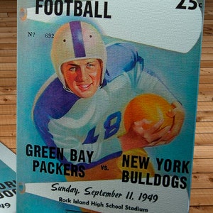Może przedstawiać: Winietkowy program meczu futbolowego z 11 września 1949 roku, przedstawiający Green Bay Packers przeciwko New York Bulldogs. Program kosztuje 25 centów i zawiera rysunek piłkarza w kasku i mundurze trzymającego piłkę.