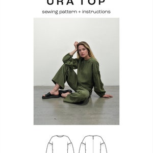 May include: A sewing pattern for a green, cropped top with puffed sleeves. The pattern is called "URA TOP" and is for sizes XS-3XL. The pattern includes instructions for sewing the top.