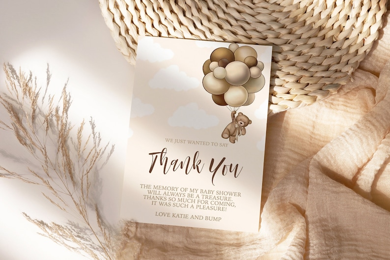 Peut inclure: Une carte de remerciement avec un ours en peluche brun tenant un bouquet de ballons bruns et beiges. La carte porte le texte "We just wanted to say Thank You" et "The memory of my baby shower will always be a treasure. Thanks so much for coming, it was such a pleasure! Love Katie and Bump."