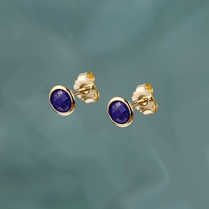 Peut inclure: Une paire de boucles d'oreilles en or avec des pierres rondes en lapis-lazuli bleu.