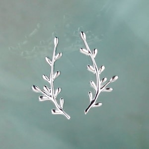 May include: A pair of silver earrings shaped like delicate branches with small leaves.