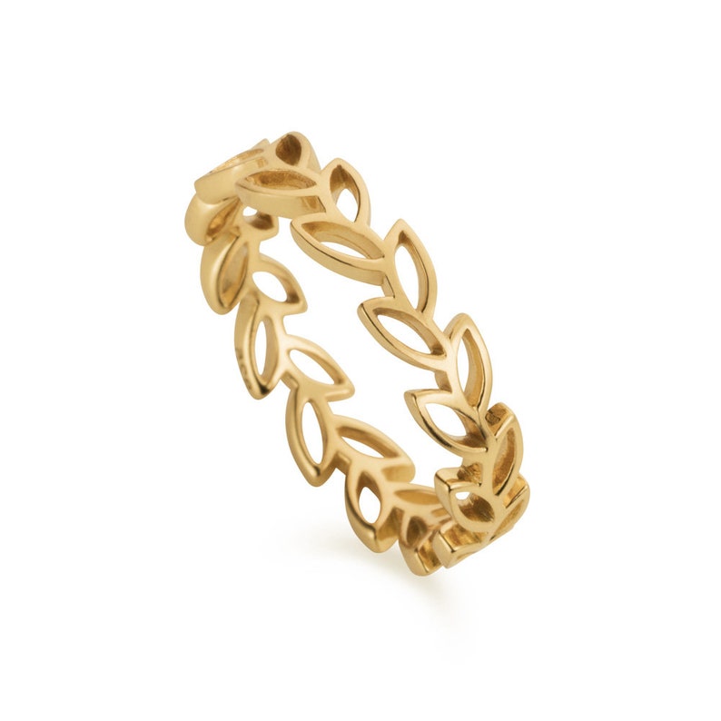 May include: A gold-toned ring with a delicate leaf design. The ring is made of metal and has a simple, elegant style.