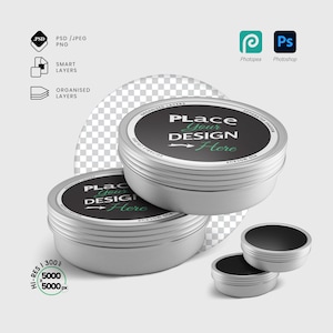 Peut inclure: Boîtes métalliques argentées avec couvercles noirs et le texte "Place Your Design Here" en blanc et vert. L'image comprend des icônes PSD, PNG et de calques intelligents, ainsi que les logos Photopea et Photoshop.