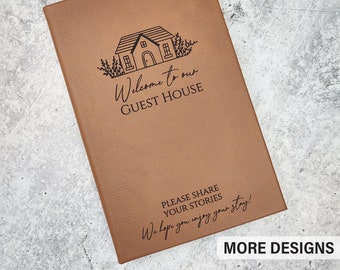 May include: A brown leather-bound journal with a house illustration and the text "Welcome to our Guest House". The journal also has the text "Please share your stories. We hope you enjoy your stay!" and "More Designs".