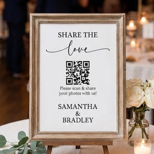 May include: A framed sign with the text "SHARE THE love" and a QR code, displayed on a wooden easel. The sign also includes the names "SAMANTHA & BRADLEY" and the phrase "Please scan & share your photos with us!"