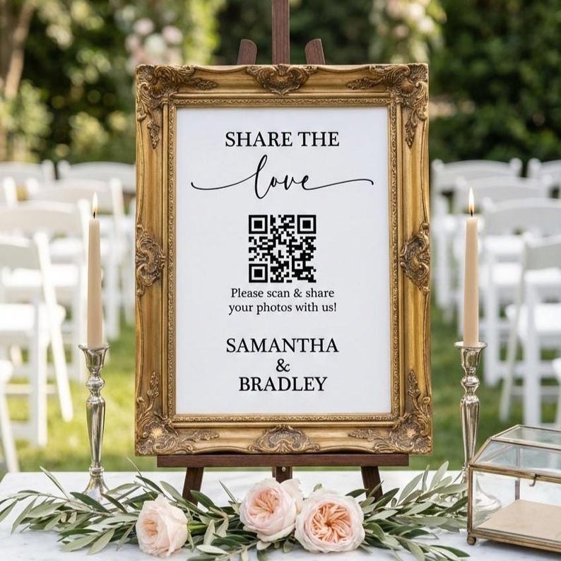 May include: A decorative gold framed sign with the text "SHARE THE love" and a QR code. The sign also includes the text "Please scan & share your photos with us!" and the names "SAMANTHA & BRADLEY".