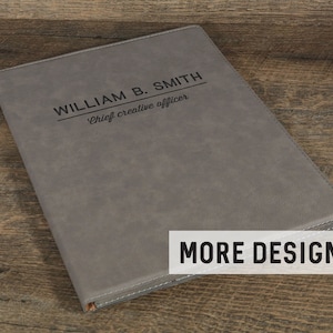 May include: Gray leatherette portfolio with the text "WILLIAM B. SMITH Chief creative officer" embossed in black.