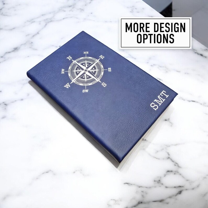 May include: A blue leather journal with a compass design and the initials "SMT" embossed on the cover.